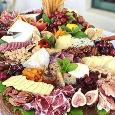 an assortment of cheeses and meats on a platter