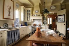 a kitchen with white cabinets and wooden table