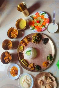 an assortment of food on a plate with bowls and utensils next to it