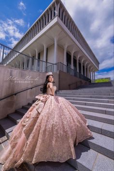 a woman in a pink dress sitting on some steps