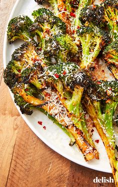 broccoli covered in parmesan cheese and sprinkles on a white plate