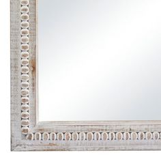 a white mirror with an intricate design on the frame and border around it, against a white background