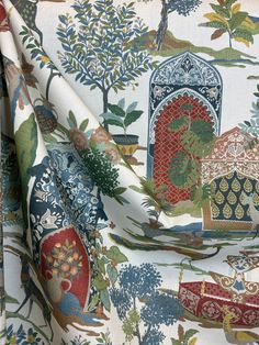 a close up view of a colorful fabric with trees and flowers on it, including an arch