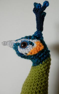 a crocheted bird is hanging on the wall