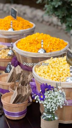 baskets filled with yellow and purple flowers sitting on top of a wooden table next to each other