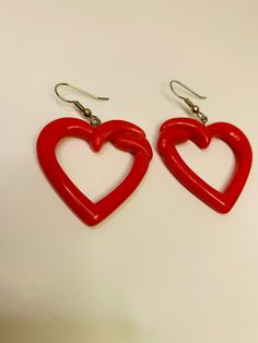 Large dangling red plastic earrings pierced. Measurements are 1 1/2 inches long by 1 1/2 inches wide. In good condition. Cheap Funky Red Jewelry, Red Plastic Earrings For Gift, Red Double Heart Pierced Earrings, Cute Red Plastic Jewelry, Vintage Red Heart Earrings For Pierced Ears, Handmade Red Plastic Earrings, Red Vintage Earrings For Valentine's Day, Quirky Red Cheap Earrings, Novelty Red Plastic Jewelry