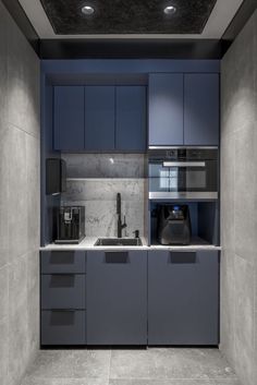 a modern kitchen with blue cabinets and marble counter tops is pictured in this image, it appears to be empty