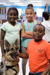 three children and a dog posing for the camera