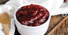 a white bowl filled with cranberry sauce on top of a wooden table