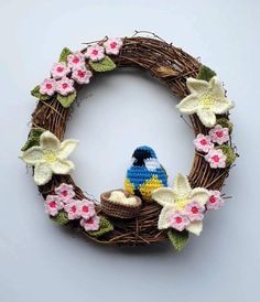 a crocheted wreath with a bird and flowers on it