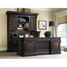 an executive desk with bookcase and lamp