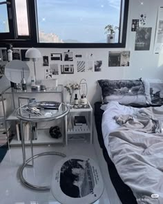 a bed sitting next to a window in a room with pictures on the wall above it