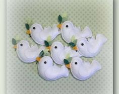 six white birds with green leaves on their heads