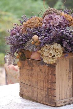 a wooden box filled with lots of purple flowers