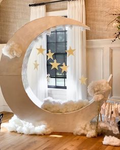 a room with a large moon and stars on the window sill in front of it