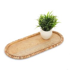 a small potted plant sitting on top of a wooden tray with beaded edge