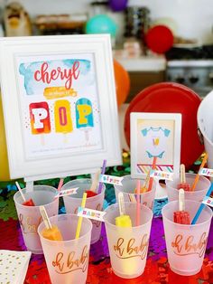 there are many cups with toothbrushes in them on the table next to each other