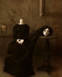 an old fashion photo of a woman sitting next to a mannequin on a table