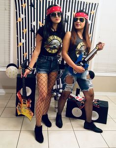 two women dressed up as rock band members posing for the camera with their guitars in front of them