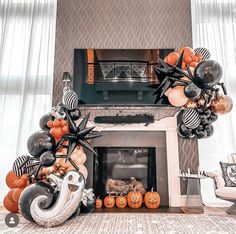 a living room decorated for halloween with pumpkins and black and white balloons in the fireplace