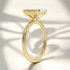 a yellow gold ring with a single diamond on the top and bottom, set against a white background