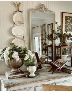 there is a vase with flowers on the table next to a mirror and other items