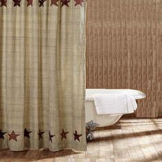 a bathroom with a bathtub, shower curtain and rugs on the wooden floor