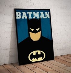 a batman poster hanging on the wall next to a wooden floor in an empty room