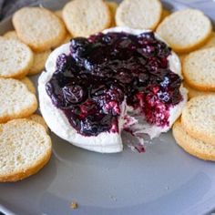 a cheesecake with blueberry sauce and crackers on a plate