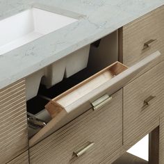 an open drawer in a bathroom sink next to a counter