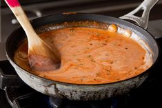 a wooden spoon in a pot of soup on the stove