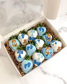 a box filled with blue and white cupcakes on top of a marble counter