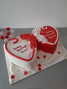 two heart shaped birthday cakes on a table