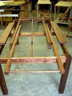 a table made out of wood in a room filled with chairs and desk top workbench