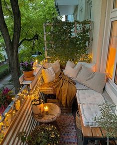 a balcony with lots of pillows and candles