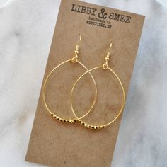 These big beaded hoops in gold or silver are the perfect simple statement — just right for those busy mornings when finding something that matches your outfit is just too much to ask. stainless steel ear wire and hand-shaped hoop with faceted beads choose gold-plated or silver-plated lead-free and nickel-free plastic earring back 2.5" long and 1.5" wide (each pair is handmade so sizes can vary slightly) packaged on a kraft earring card in a clear resealing bag Chakra Earrings, Hoop Earrings Big, Earrings Gold Hoops, Gifts For Girlfriends, Earring Inspiration, Plastic Earrings, Long Tassel Earrings, Dangle Hoop Earrings, Earrings Big