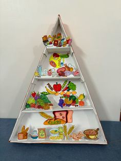 a white shelf filled with different types of food on top of a blue tablecloth covered floor