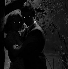 a man and woman are hugging in the dark