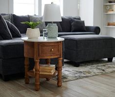 a living room with a couch, coffee table and lamp