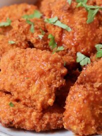 some fried food on a white plate with parsley