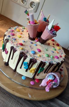 a birthday cake with sprinkles and decorations on the top is ready to be eaten