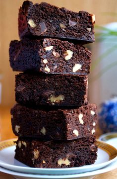 a stack of brownies sitting on top of a white plate