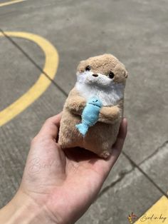 a small stuffed animal is held in someone's hand