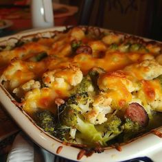 a casserole dish with broccoli, sausage and cheese