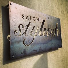 a metal sign that says salon stylish on it