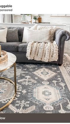 a living room with couches and rugs on the floor in front of a window