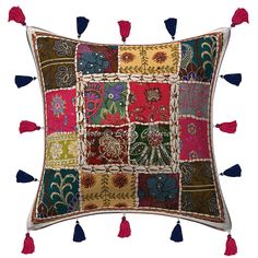 an embroidered pillow with tassels and flowers on the front, in multicolored squares