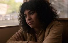 a woman with curly hair sitting at a table