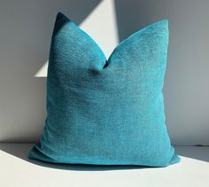 a blue pillow sitting on top of a white table