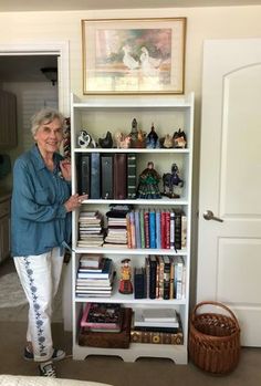 an older woman standing in front of a book shelf